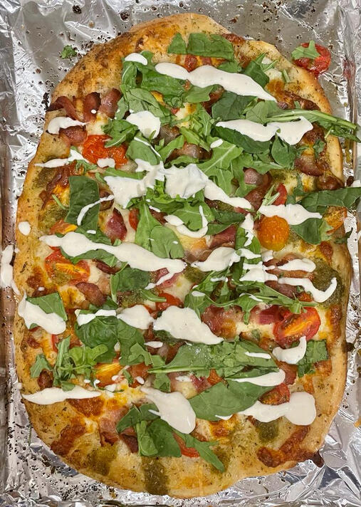argula, pesto & tomato pizza with garlic lime mayo drizzle